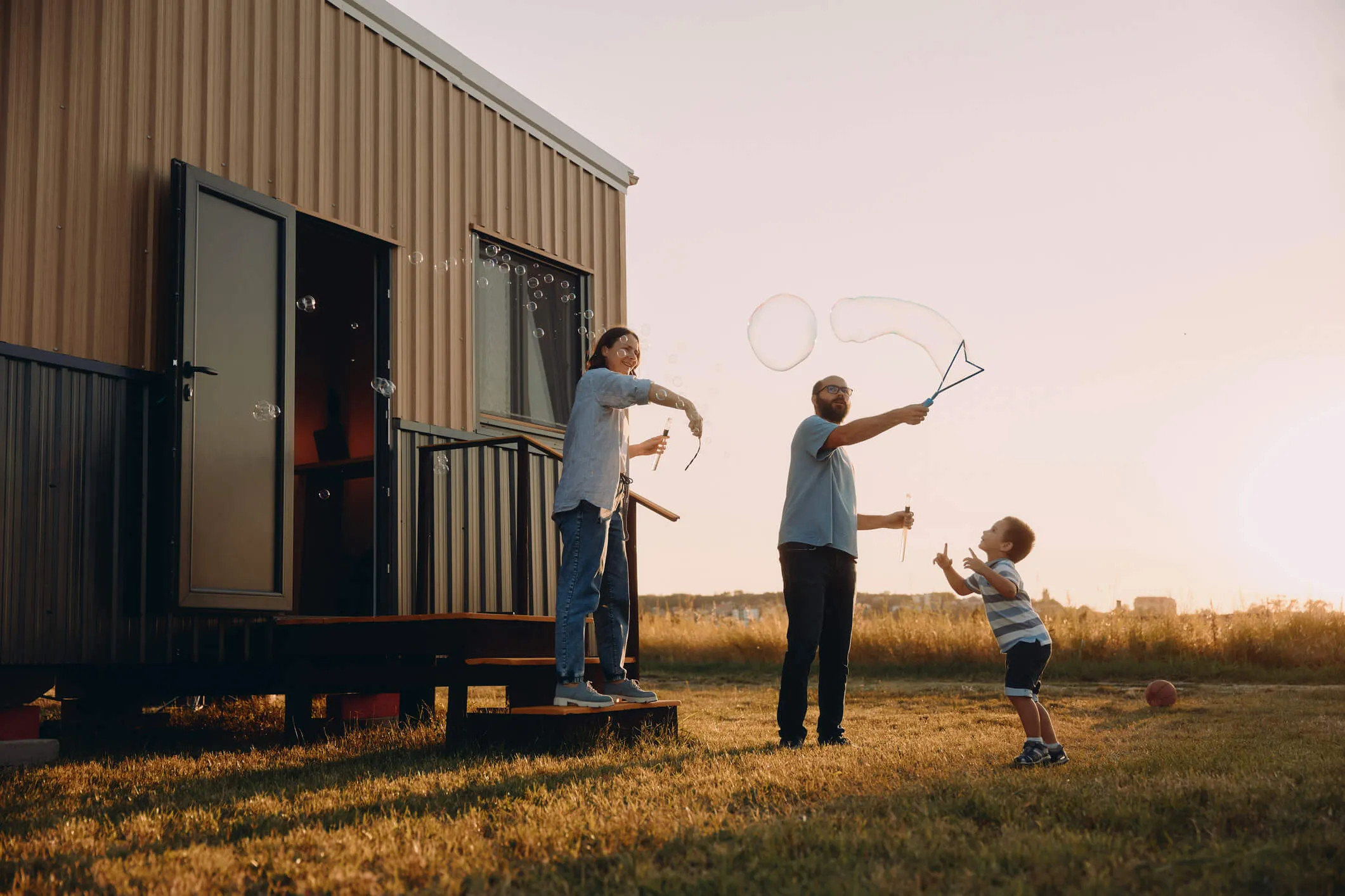 A family enjoying their manufactured home on their own land at golden hour